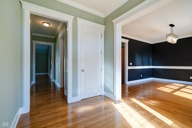 7290 Lockford Walk N, Avon, IN 46123 - spare room featuring wood finished floors, baseboards, crown molding, and a chandelier