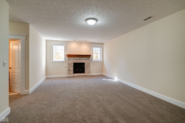 unfurnished living room featuring a textured ceiling, light colored carpet, and a fireplace