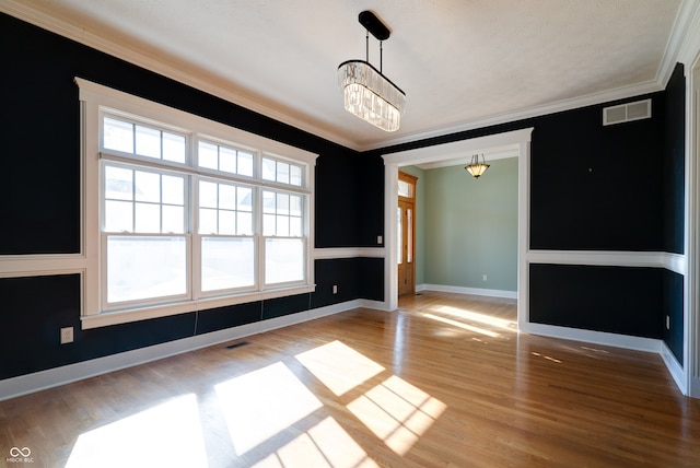 unfurnished dining area with ornamental molding, light hardwood / wood-style flooring, and an inviting chandelier