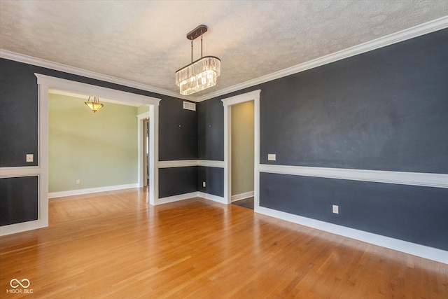 7290 Lockford Walk N, Avon, IN 46123 - spare room featuring a chandelier, wood finished floors, a textured ceiling, and ornamental molding
