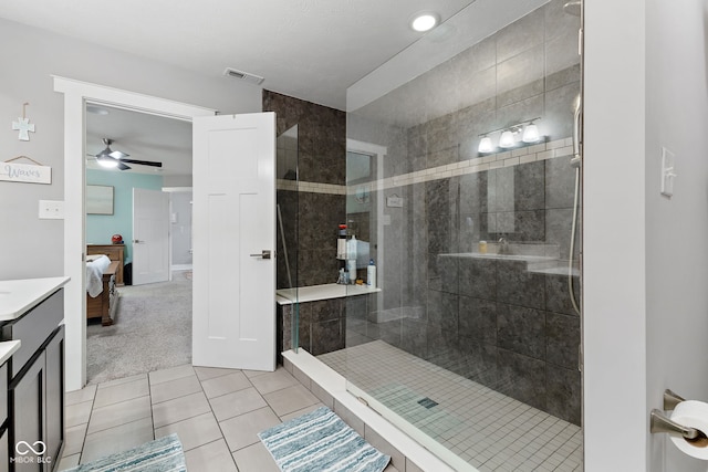 bathroom with ceiling fan, tile patterned flooring, vanity, and tiled shower