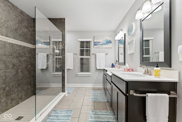 bathroom with tile patterned floors, vanity, and tiled shower