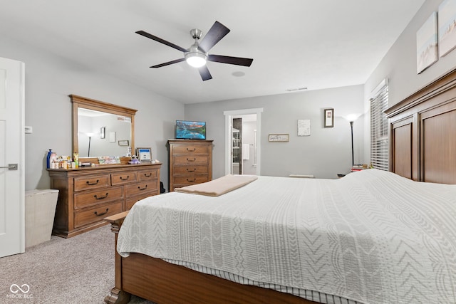 carpeted bedroom with ceiling fan and ensuite bath