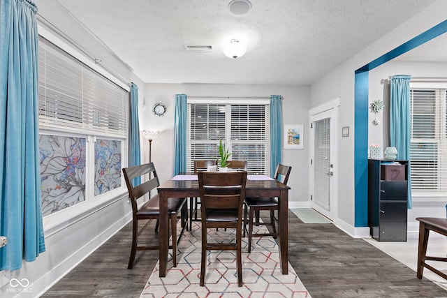 dining area featuring a textured ceiling and dark wood-type flooring