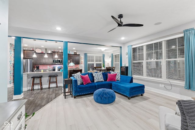 living room featuring ceiling fan and light hardwood / wood-style flooring