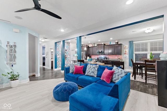 living room featuring ceiling fan and light hardwood / wood-style floors