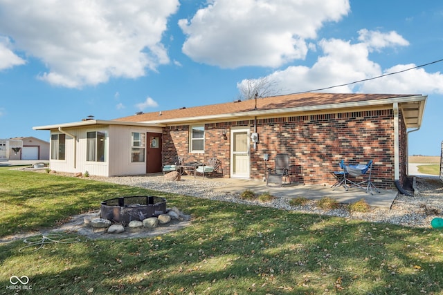 rear view of house featuring a fire pit, a lawn, and a patio area