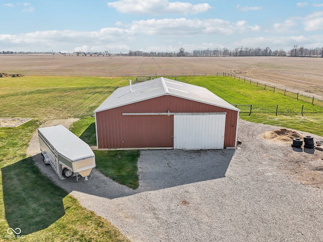 view of outbuilding featuring a rural view and a yard