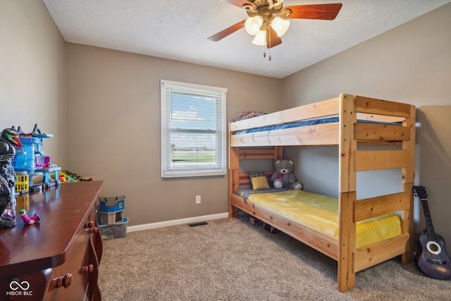 carpeted bedroom featuring a textured ceiling and ceiling fan