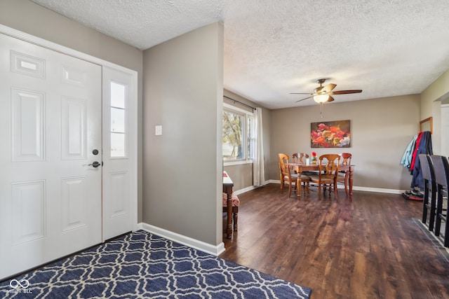 entrance foyer with ceiling fan, a textured ceiling, and dark hardwood / wood-style floors