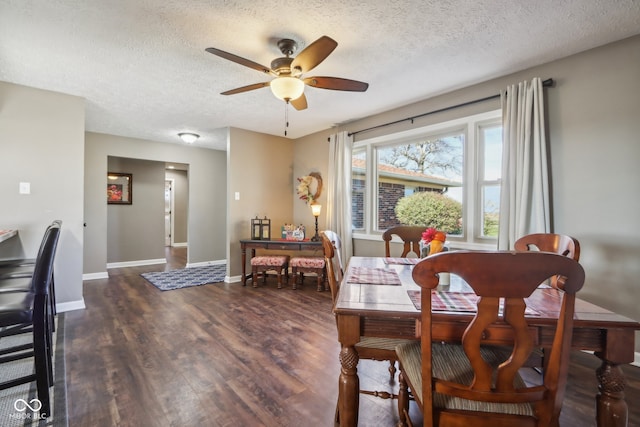 dining space featuring a textured ceiling, dark hardwood / wood-style floors, and ceiling fan