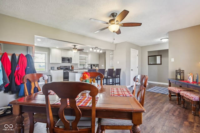 dining room with dark wood-type flooring, a textured ceiling, and ceiling fan