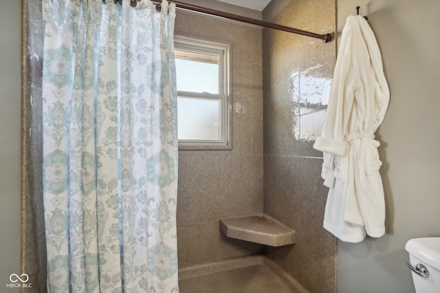 bathroom featuring walk in shower and toilet