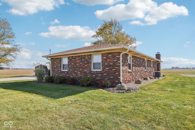 view of home's exterior with a lawn and central AC