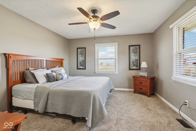 carpeted bedroom with a textured ceiling and ceiling fan