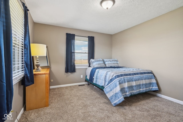 bedroom featuring a textured ceiling and carpet flooring