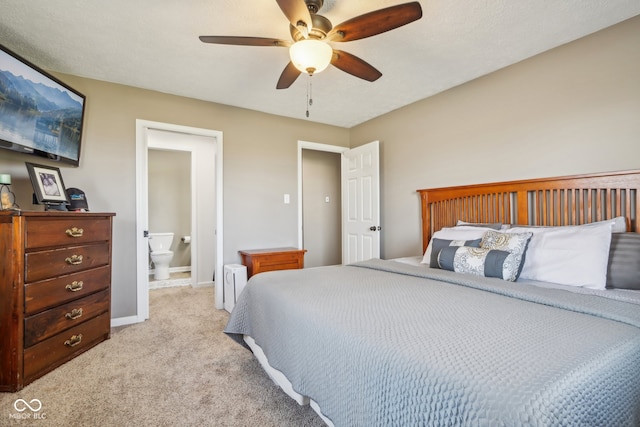 bedroom with light colored carpet, ceiling fan, and ensuite bathroom