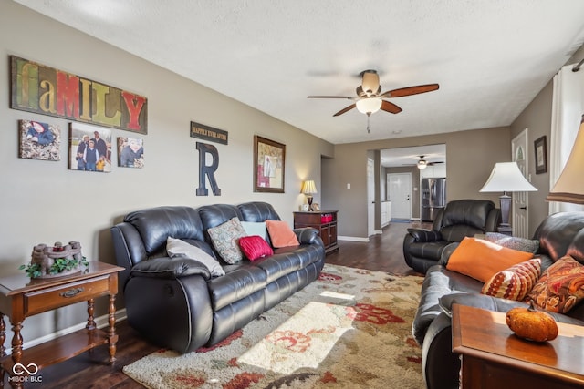 living room with a textured ceiling, dark hardwood / wood-style flooring, and ceiling fan