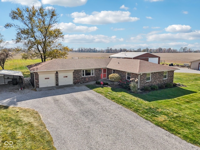 single story home featuring a garage, a rural view, and a front lawn