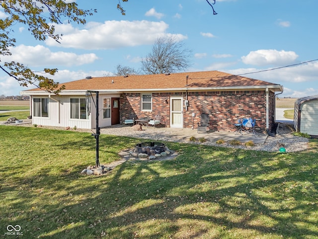 back of house featuring a yard, an outdoor fire pit, and a patio area