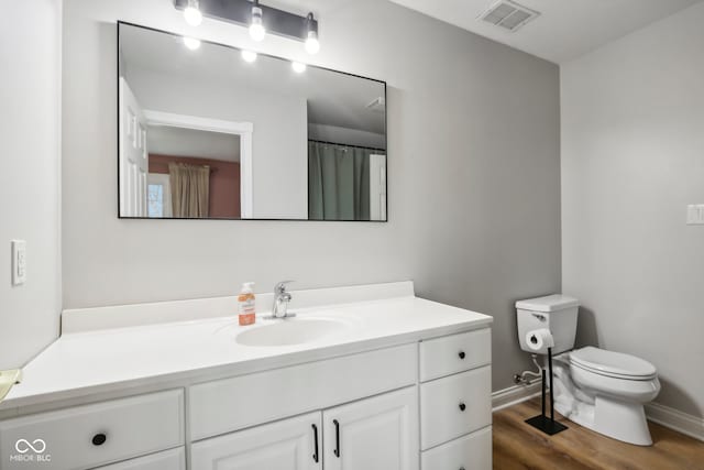 bathroom with hardwood / wood-style flooring, vanity, and toilet