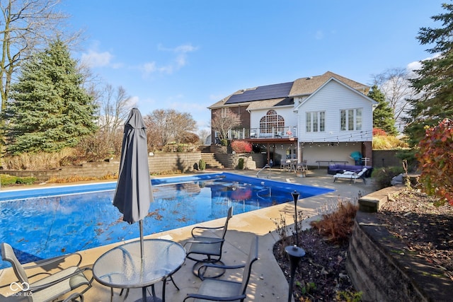 view of swimming pool with a wooden deck and a patio