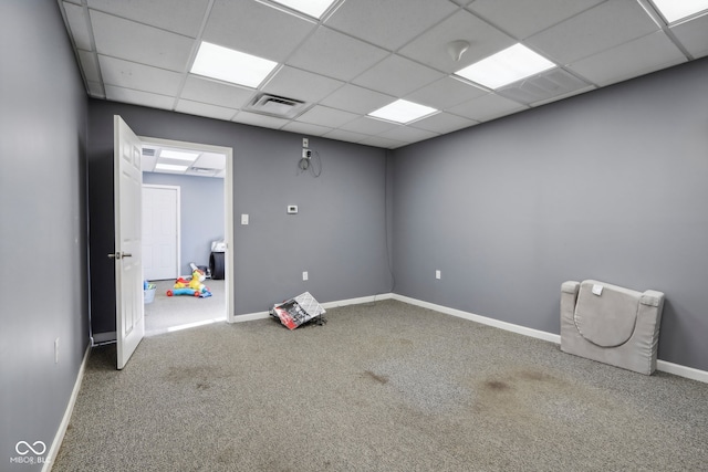 unfurnished room featuring carpet flooring and a drop ceiling