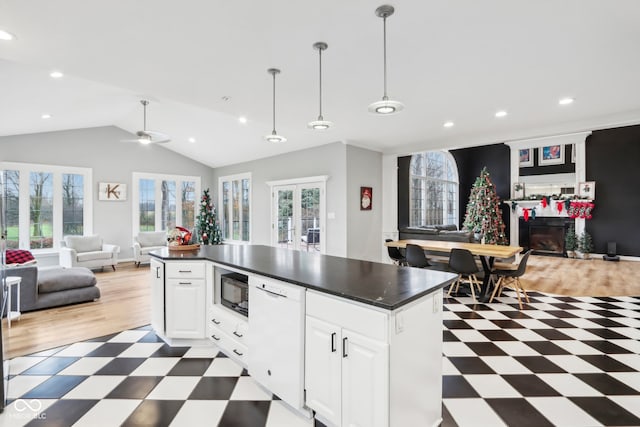 kitchen with lofted ceiling, white cabinetry, and a healthy amount of sunlight