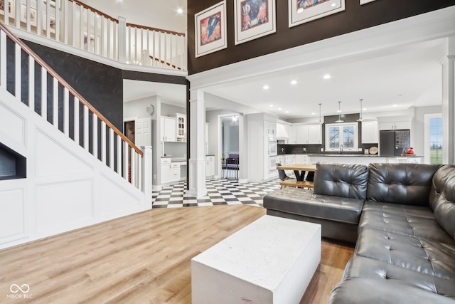 living room with ornate columns and light hardwood / wood-style flooring