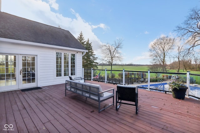 wooden terrace with a fenced in pool, an outdoor hangout area, and french doors