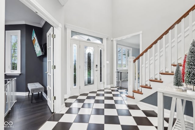 foyer entrance featuring a healthy amount of sunlight, dark hardwood / wood-style flooring, and crown molding