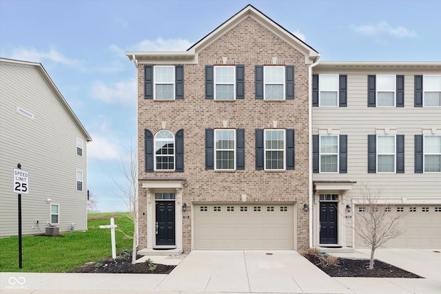 7282 Zanesville Rd, Carmel, IN 46033 - townhome / multi-family property with an attached garage, brick siding, driveway, and central AC
