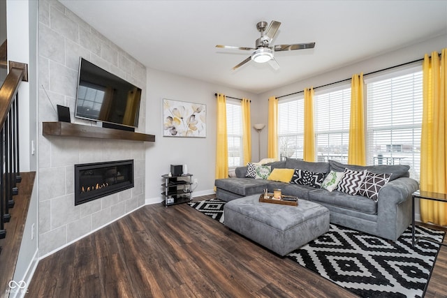 7282 Zanesville Rd, Carmel, IN 46033 - living room featuring a tiled fireplace, wood finished floors, baseboards, and ceiling fan