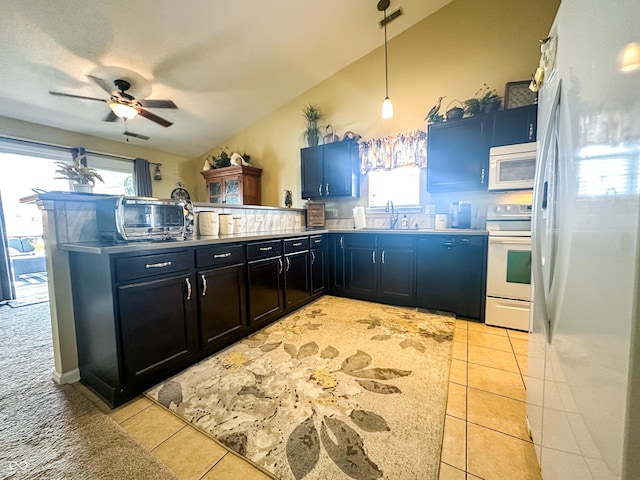 kitchen featuring white appliances, a healthy amount of sunlight, a peninsula, and light tile patterned floors