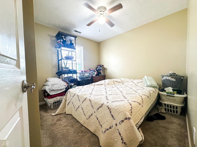 bedroom featuring carpet, a textured ceiling, visible vents, and a ceiling fan