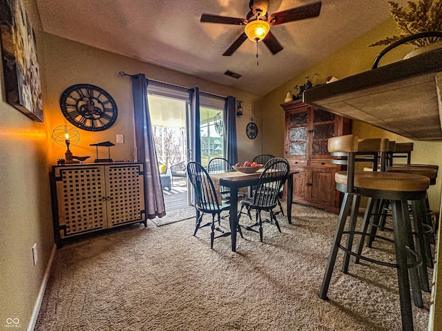 dining area with lofted ceiling, carpet floors, a textured ceiling, and a ceiling fan