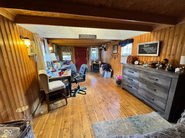 interior space featuring light wood-type flooring, wooden walls, and beam ceiling