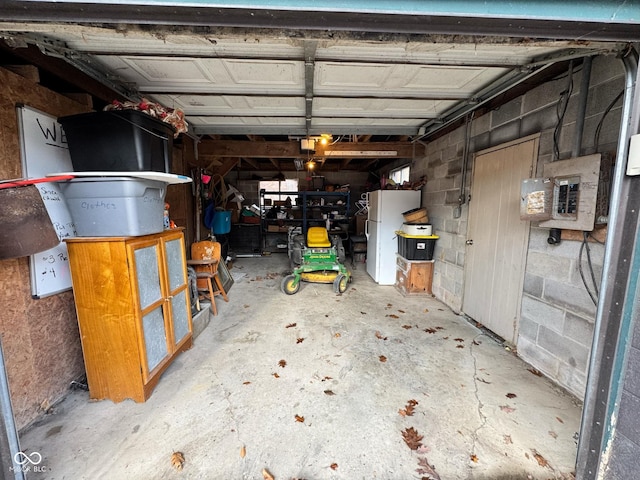 garage featuring electric panel and white refrigerator