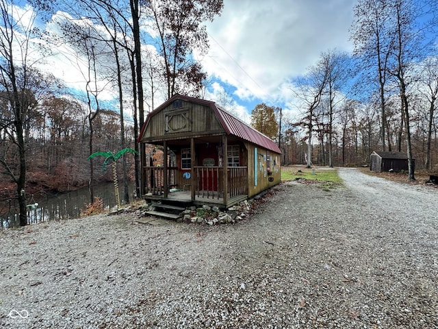 view of front of property with a porch and a storage unit