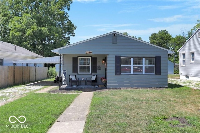 bungalow-style home with a front lawn and covered porch