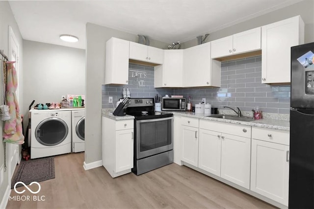 kitchen with stainless steel appliances, white cabinets, light wood-type flooring, and independent washer and dryer