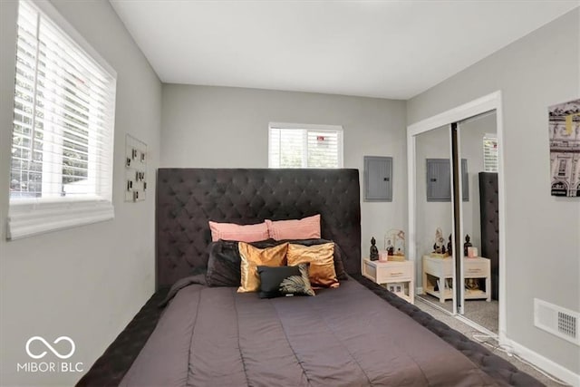 carpeted bedroom with electric panel and a closet