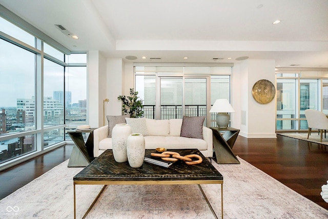 living room featuring a wealth of natural light, hardwood / wood-style flooring, and a wall of windows