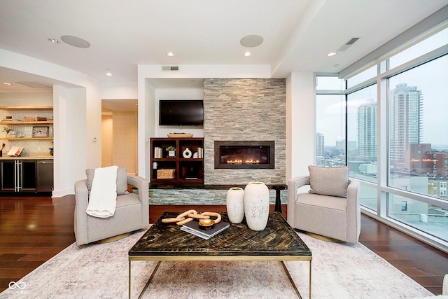 living room featuring a wall of windows, a fireplace, and hardwood / wood-style flooring