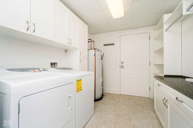 laundry room with cabinets, washing machine and dryer, and water heater