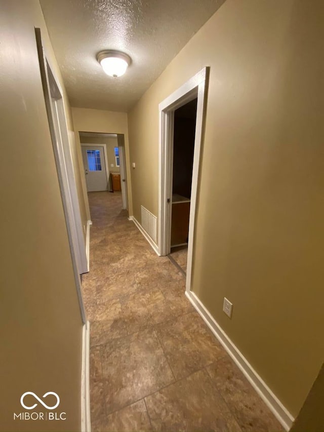 hall with a textured ceiling