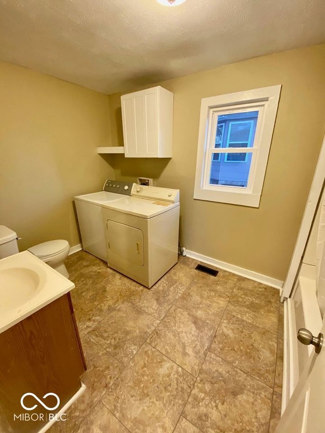 laundry room with a textured ceiling and washer and dryer