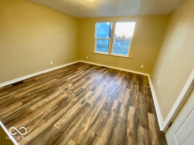 empty room featuring dark wood-type flooring