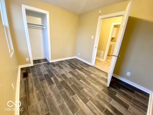 unfurnished bedroom featuring a closet and dark hardwood / wood-style flooring