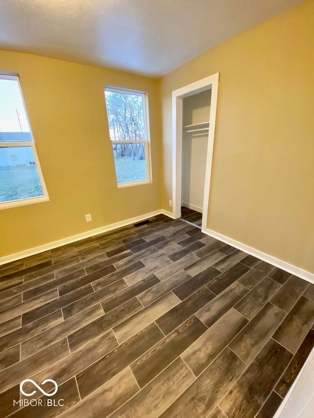 unfurnished bedroom with a closet and dark wood-type flooring